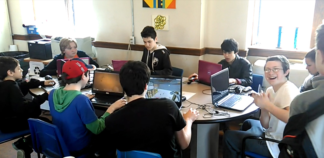 Students co‑op building on laptops during a Minecraft club